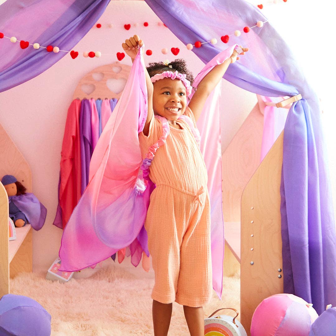 Child in a playroom with colorful curtains and decorations