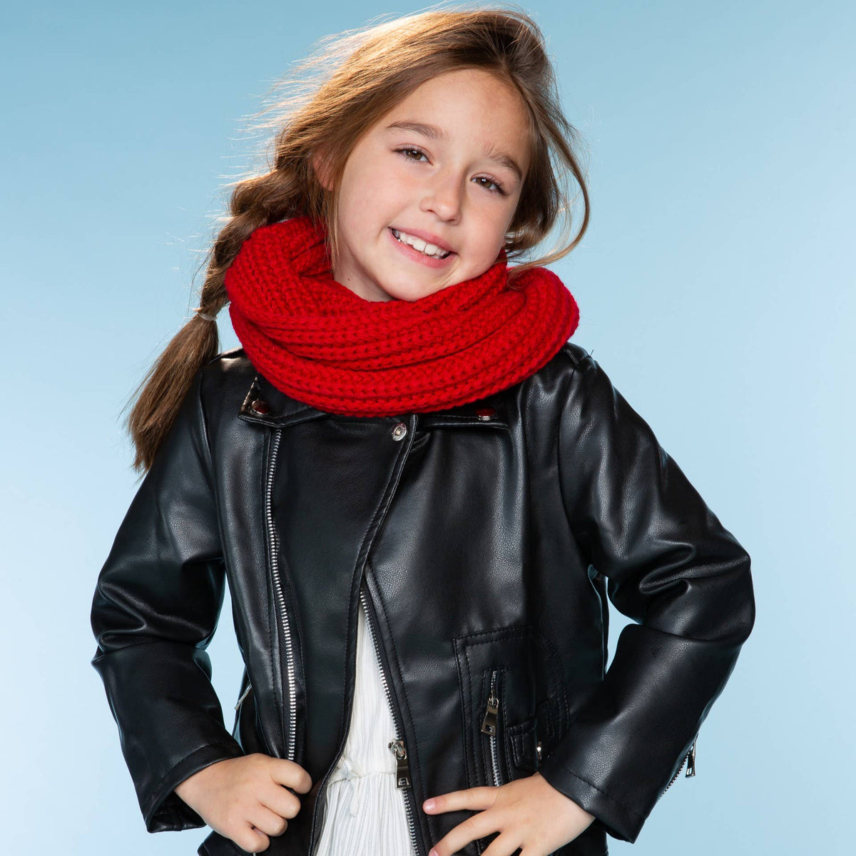 Girl wearing a black leather jacket and red scarf on a light blue background