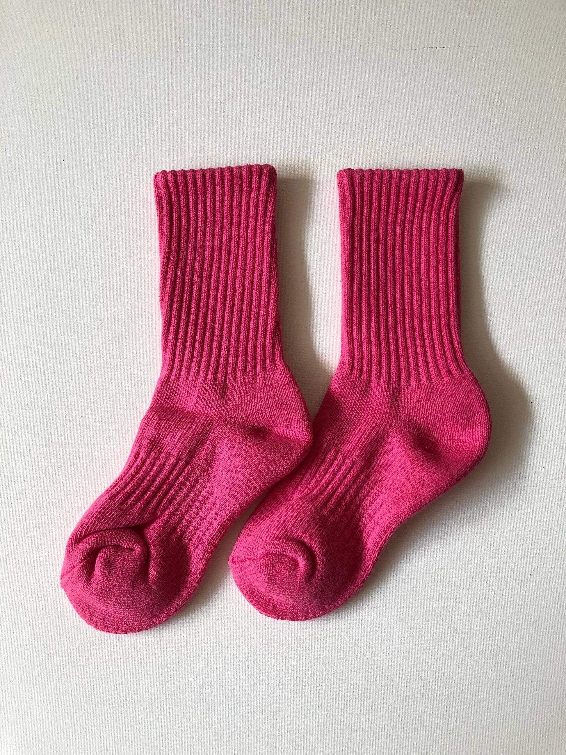 Pair of bright pink socks on a light gray background