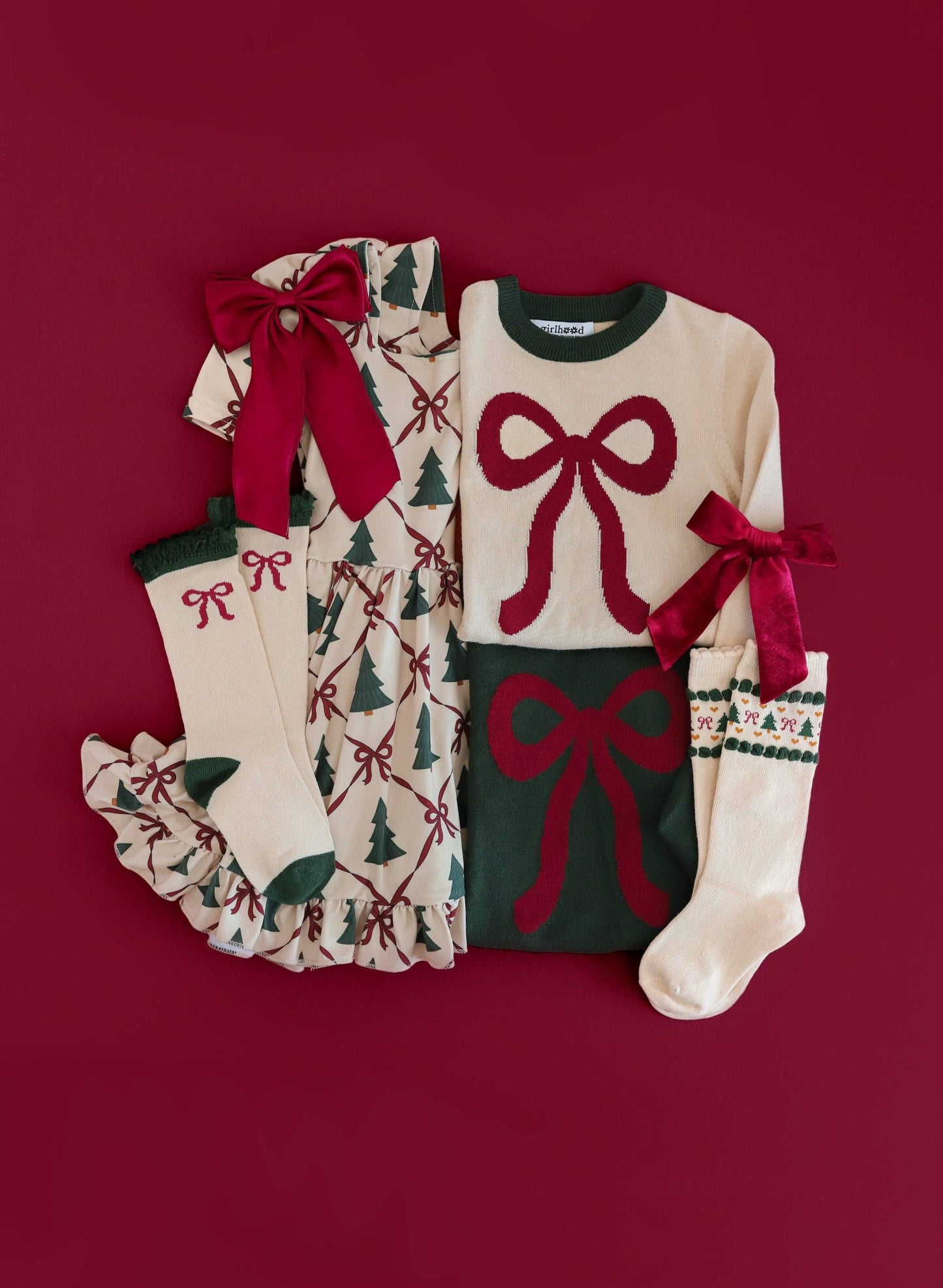 Christmas-themed children's outfit with sweater, leggings, and socks on a red background