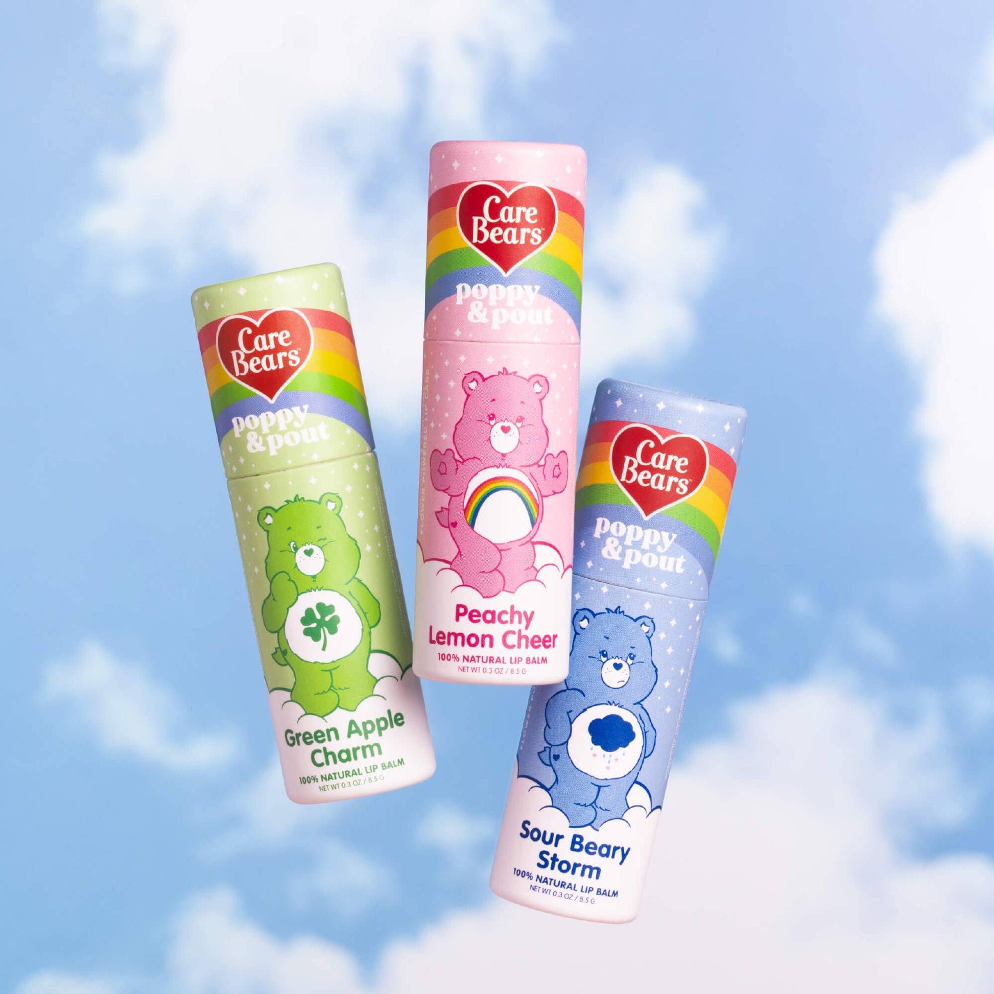 Three Care Bears lip balms with colorful packaging against a blue sky background