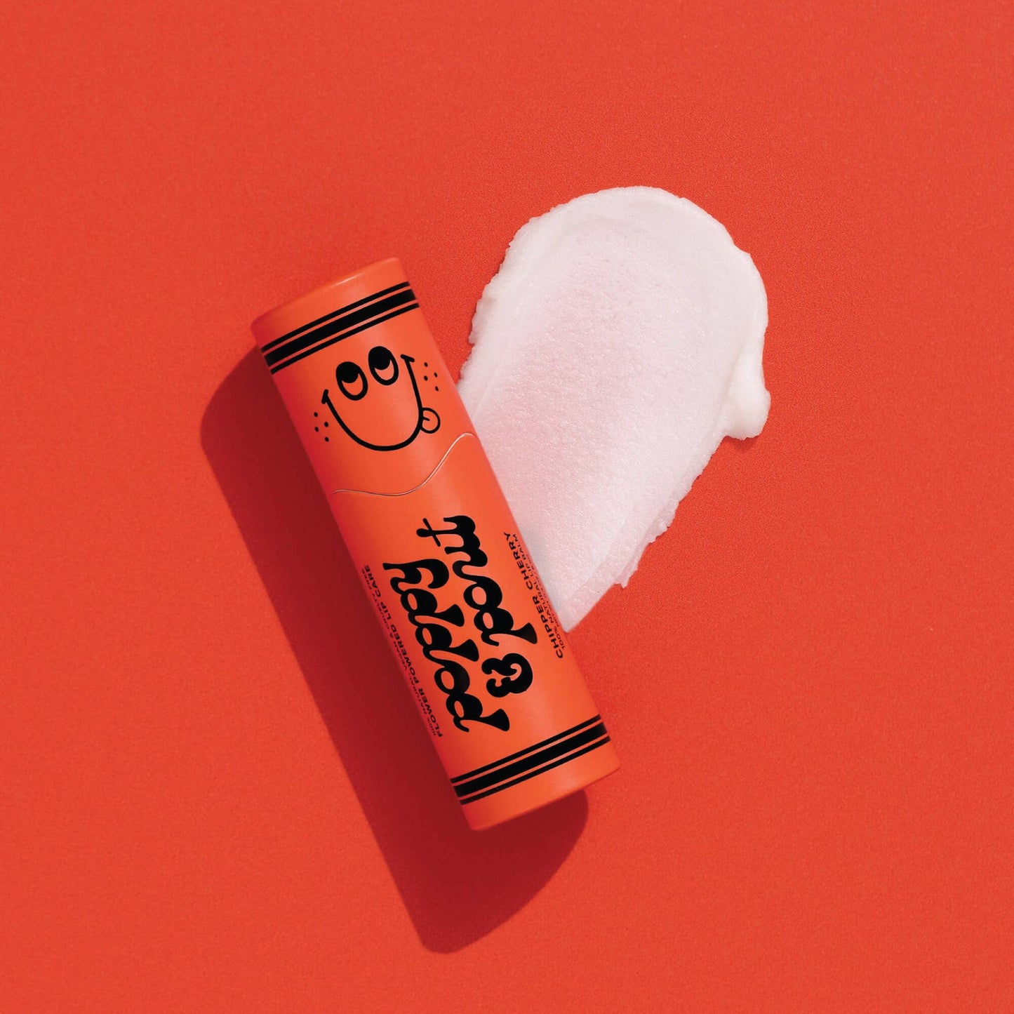 red lip balm with a smiley face on a red background